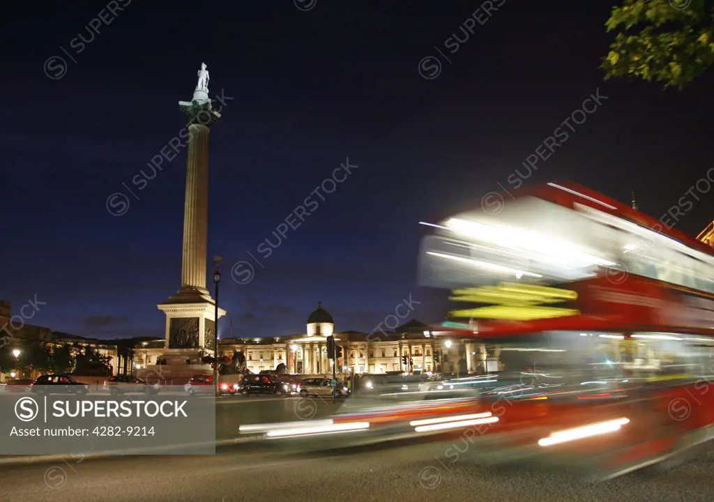 England, London, Trafalgar Square. Trafalgar Square at night as a red bus goes past in Central London.