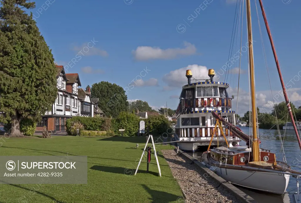 England, Norfolk, Horning. A sailing boat and pleasure boat moored on the River Bure at Horning Staithe.