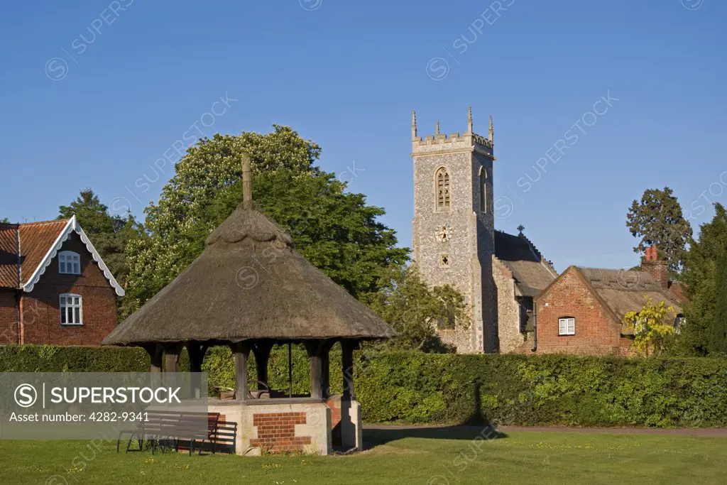 England, Norfolk, Woodbastwick. The attractive village and green of Woodbastwick in Norfolk, surrounded by many thatched houses and the thatched church of  St Fabian & St Sebastian.