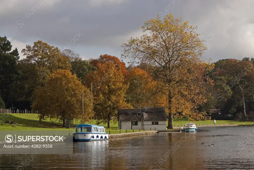 England, Norfolk, Coltishall. Boats moored on the River Bure at Coltishall in the Norfolk Broads in autumn.