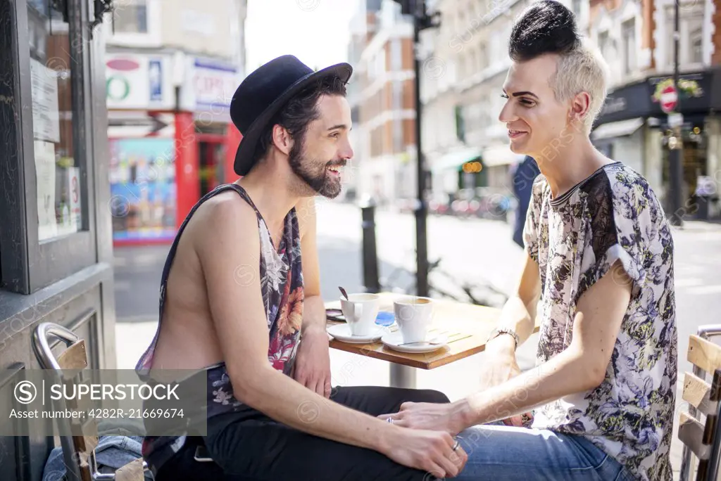 A gay couple chat outside a coffee shop in London.