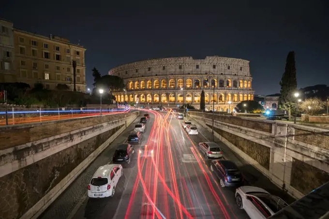 Traffic paints light trails as it speeds past the Colosseum in Rome in Italy.