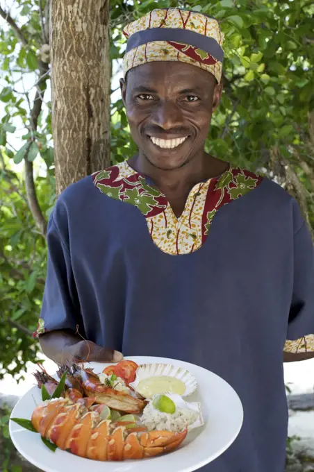 Waiter with lobster lunch dish at Guludo beach lodge in the Quirimbas National Park in northern Mozambique.