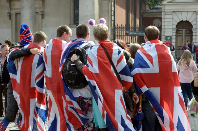 England, London, Covent Garden. A group of revellers draped in Union Jack flags.