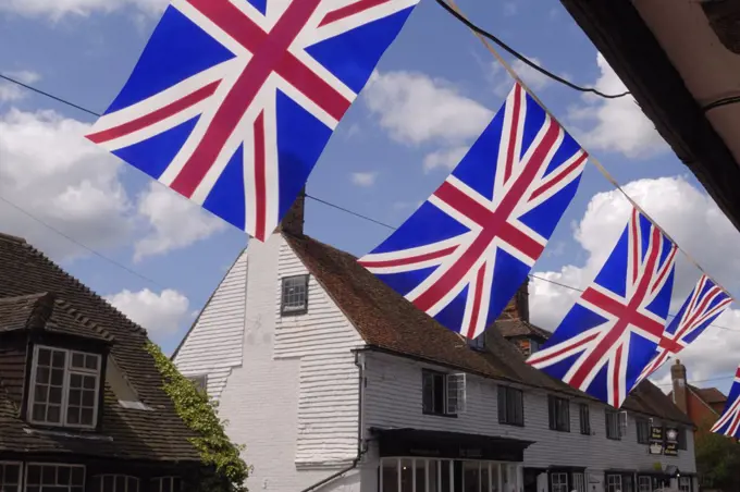 England, Kent, Brenchley. Bunting hanging underneath the overhang of a tudor house in celebration of the Tour de France passing through the village.