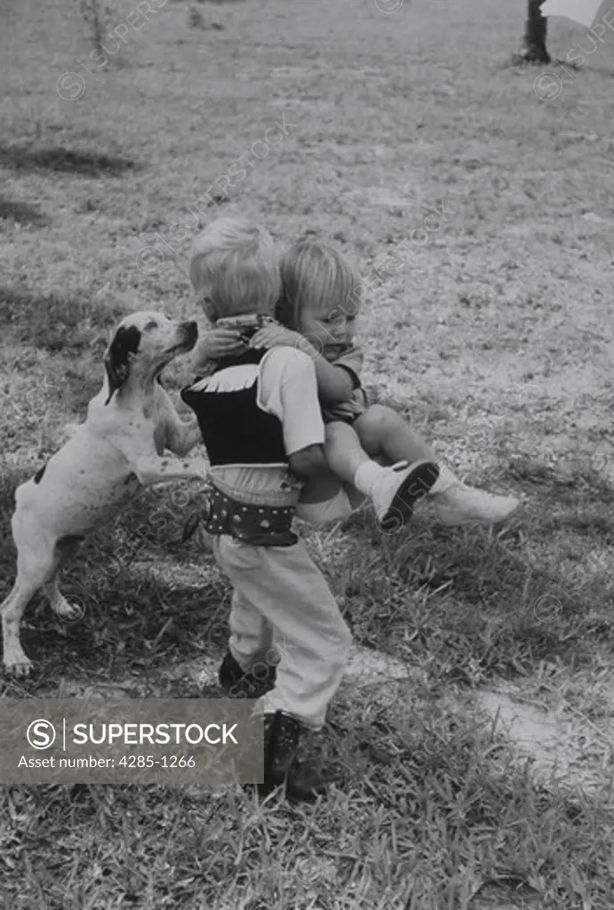 Big brother carries little sister to safety when dog frightens her.