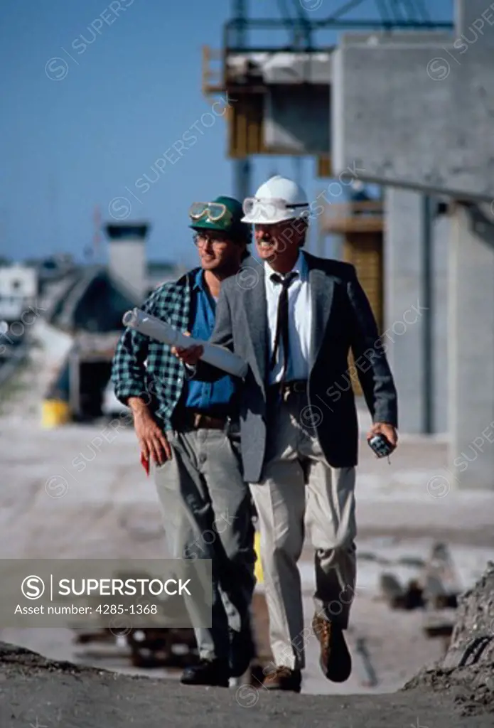 Two men walking on construction site.