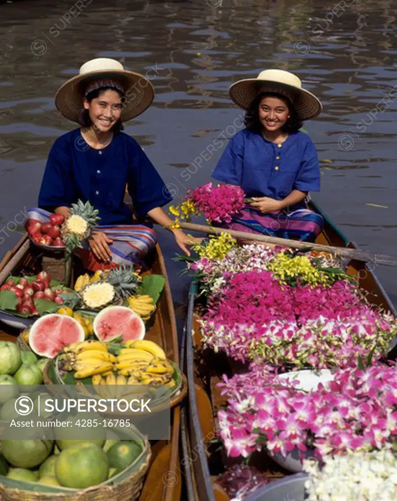 Girls in Boats selling flowers and fruit in the Floating Market, Damneon Saduak, Thailand