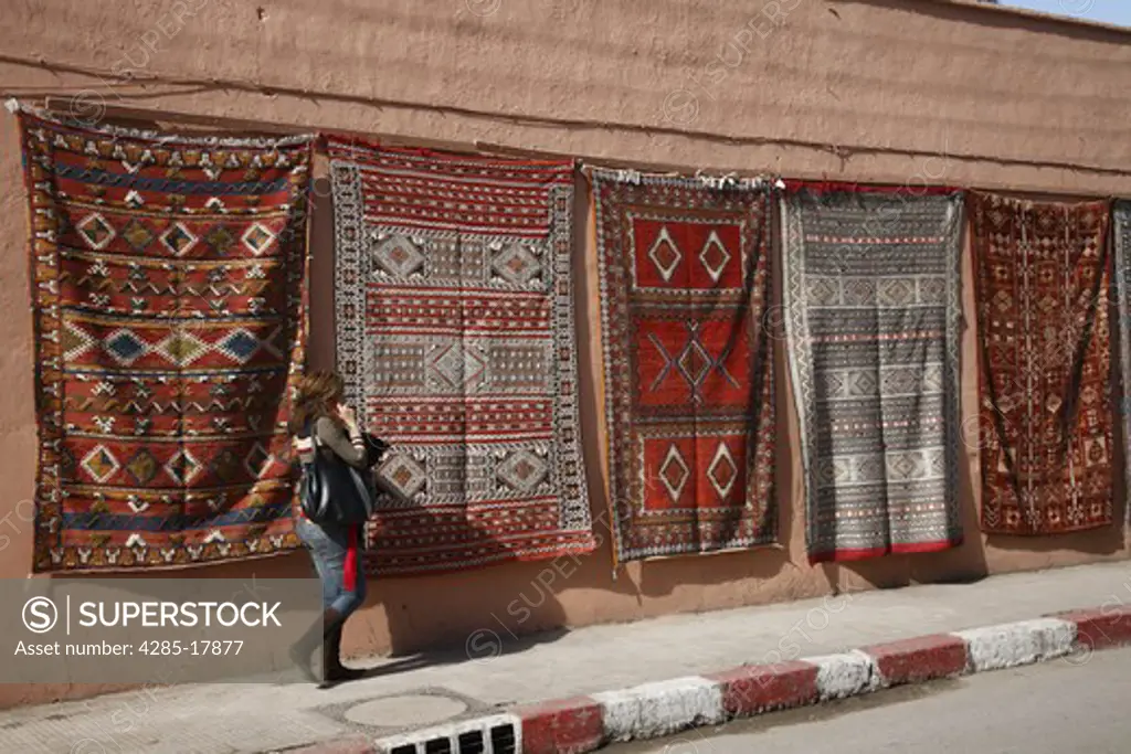Africa, North Africa, Morocco, Marrakech, Medina, Hanging Carpets, Modern Dressed Woman talking on Mobile Phone