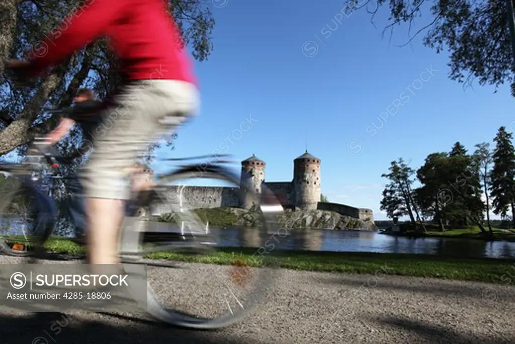 Finland, Region of Southern Savonia, Saimaa Lake District, Savonlinna, Kyronsalmi Straits, Olavinlinna Medieval Castle, St. Olaf's Castle, Cyclist