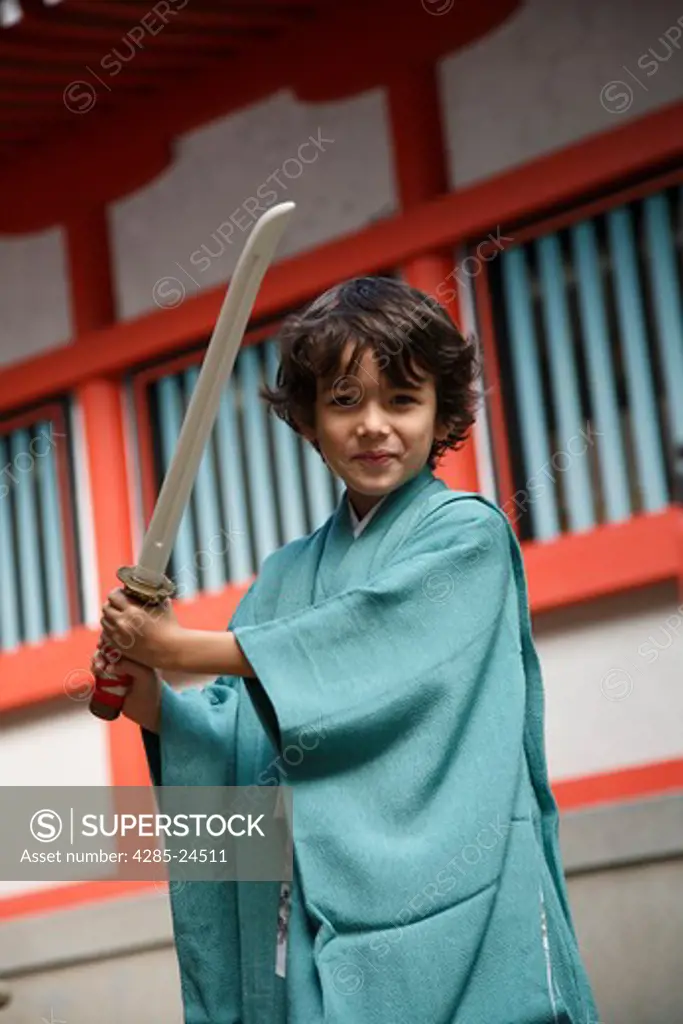 Japan, Tokyo, Young Boy in Kimono holding Sword