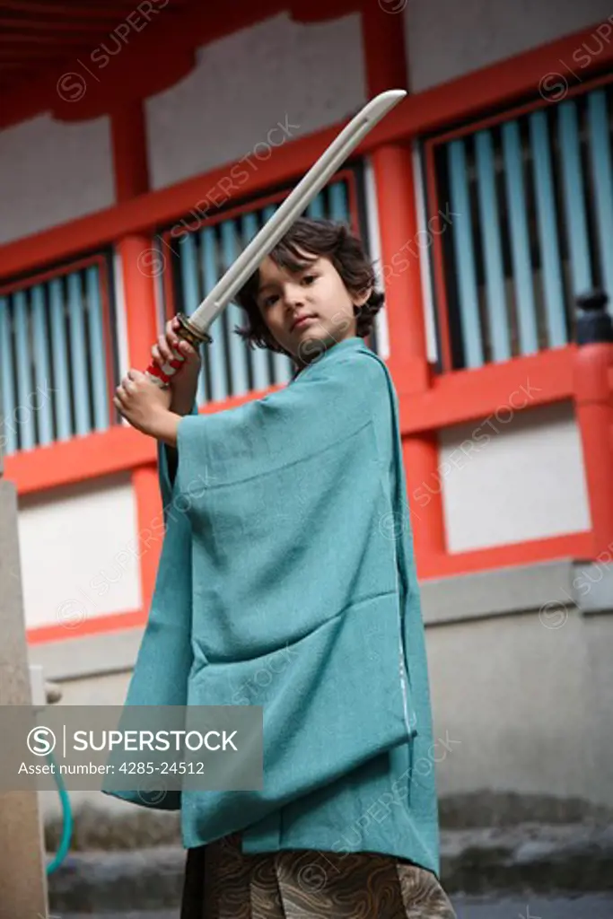 Japan, Tokyo, Young Boy in Kimono holding Sword