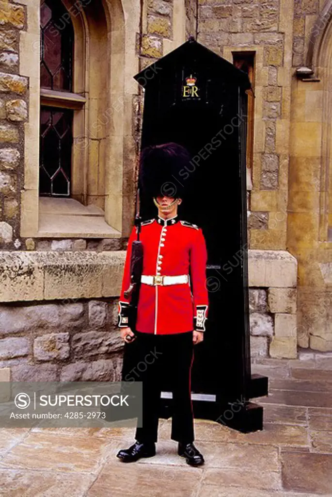 A member of the Grenadier Guards stands guard in his traditional red tunic and bearskin hat.