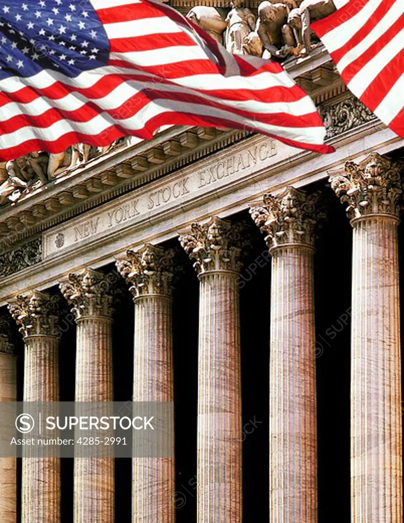 Exterior of the New York Stock Exchange seen between American flags.