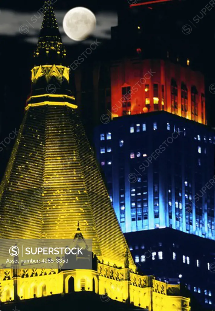 New York Life building and Empire State building in Manhattan at night lighted with colors and full moon in the background.