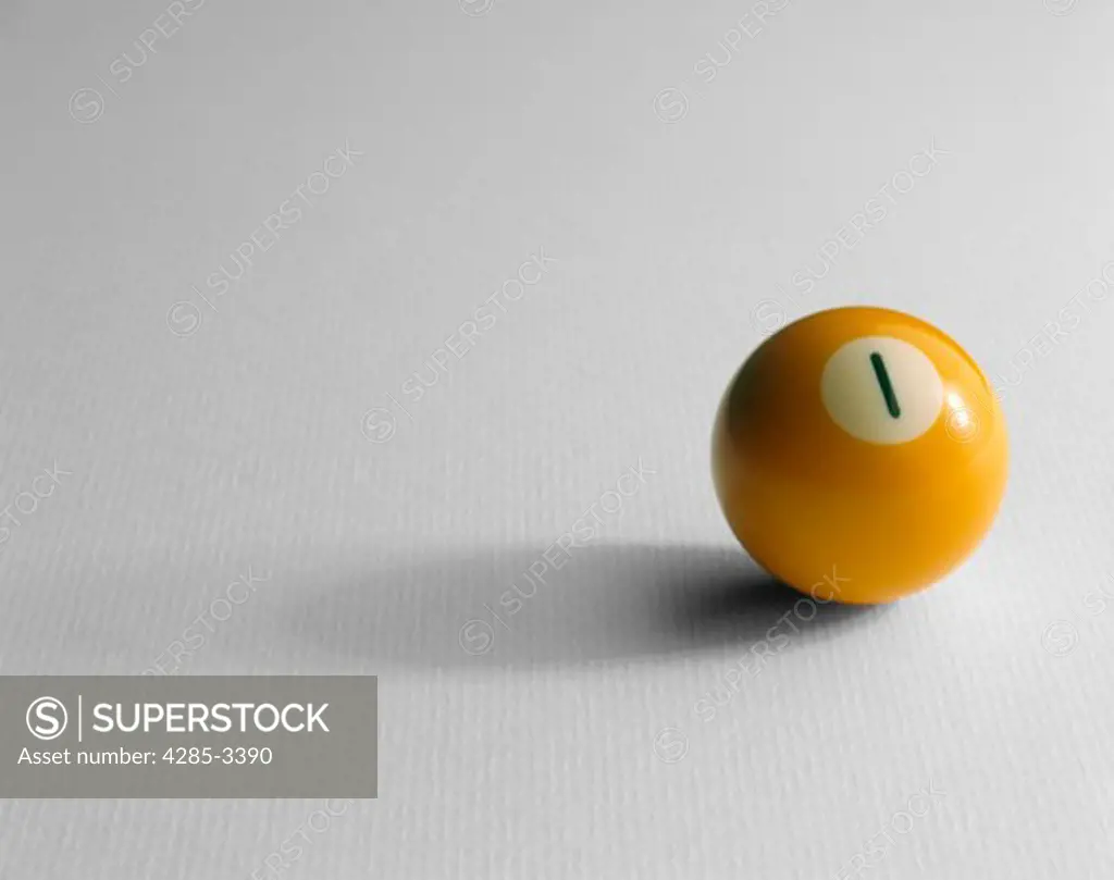 Single yellow #1 pool ball sitting on white textured background with long shadow.