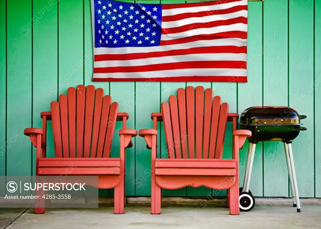 RED CHAIRS GREEN WALL, BARBECUE AND AMERICAN FLAG