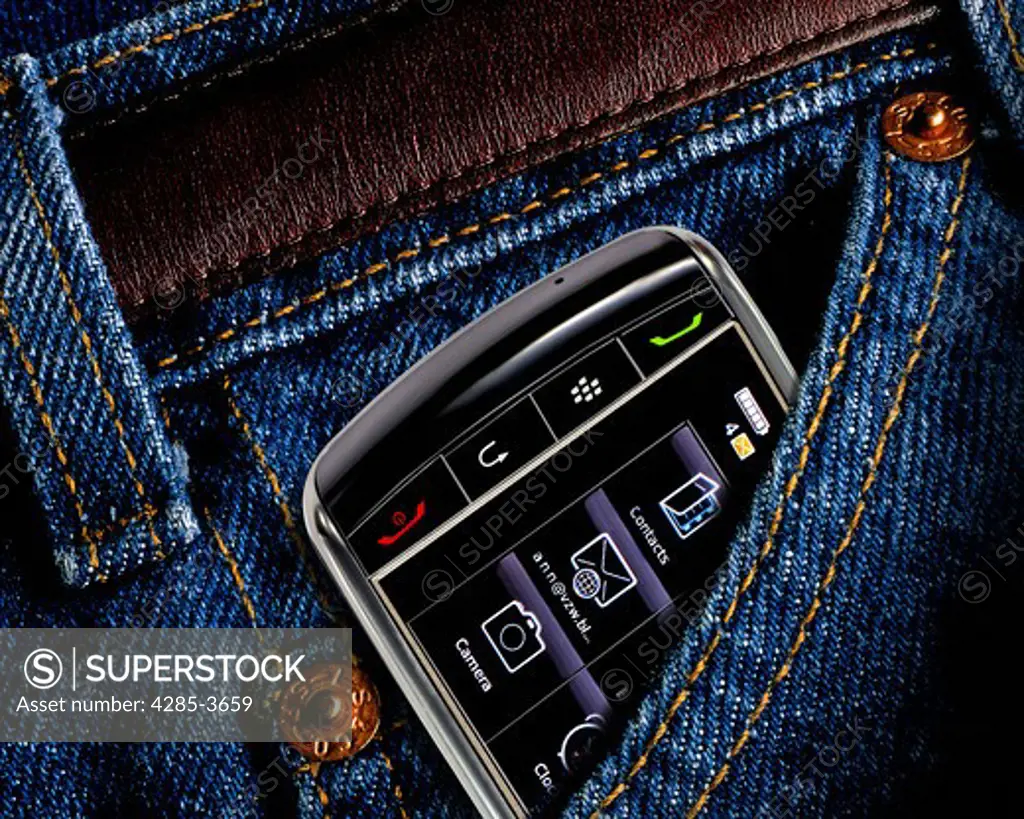 CLOSEUP OF CELL PHONE DEVICE PARTLY TUCKED INTO BLUE JEANS POCKET