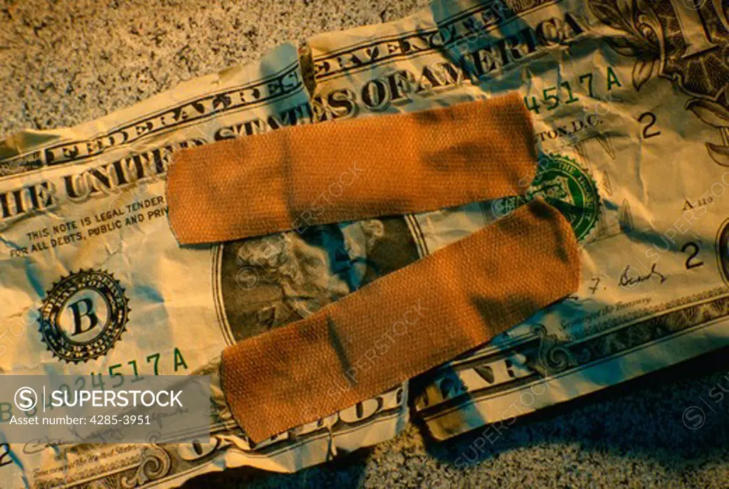 Torn dollar bill bandaged together.