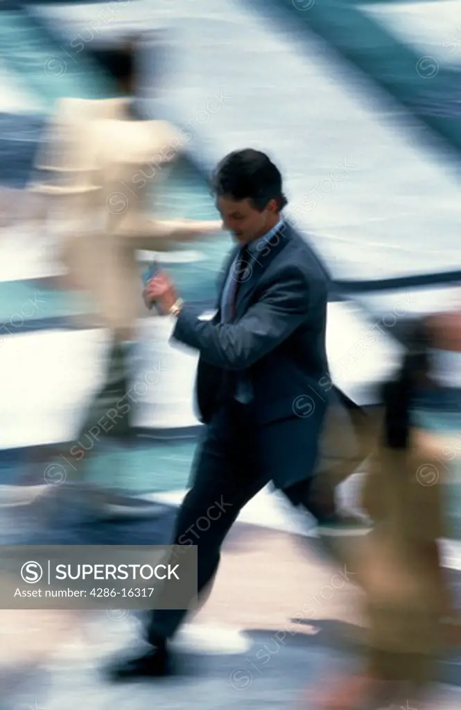 Man walking, looking at watch, blurred