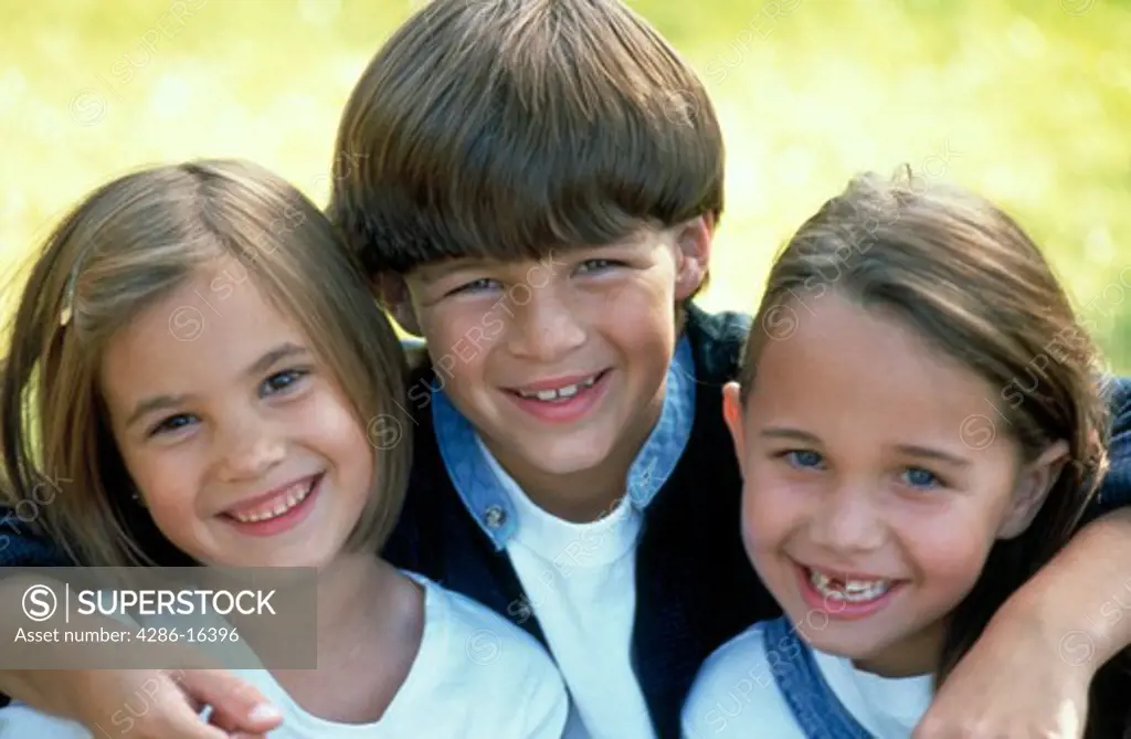Portrait of two girls and a boy smiling.