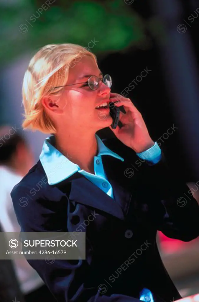 A female executive outside talking on a cellular phone.