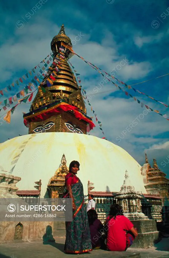 A woman standing in the foreground outside the Soyambu Temple in Kathmandu, Nepal.