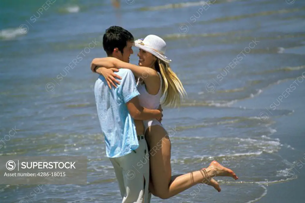 Couple embrace on beach.