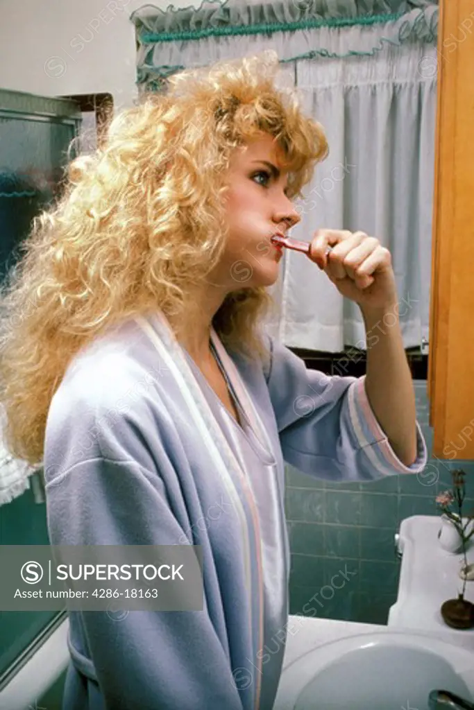 Woman brushes teeth.