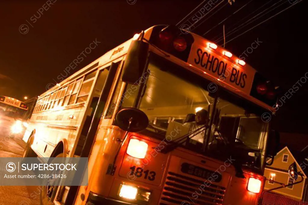 Yellow school bus at a nighttime fair waiting to pick up people.