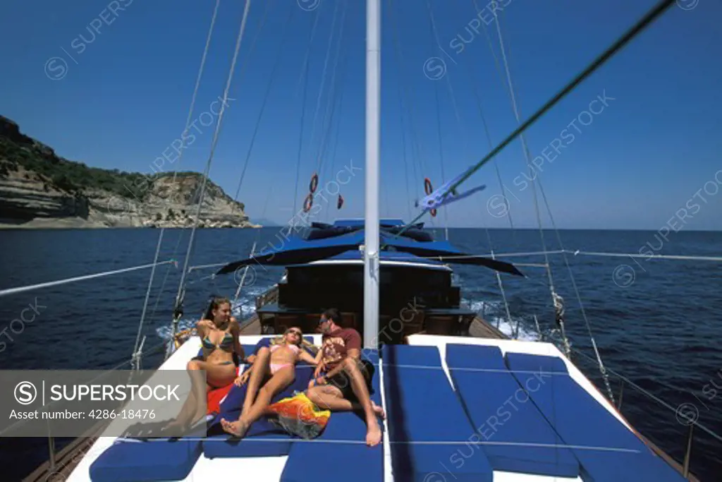 Friends relax on sail boat.