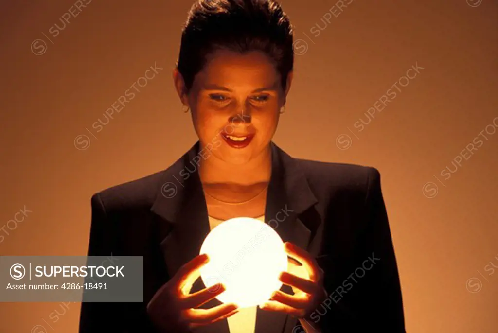 Woman gazes at glowing globe.