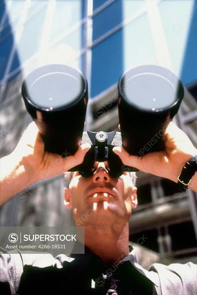 Man peers through powerful binoculars.