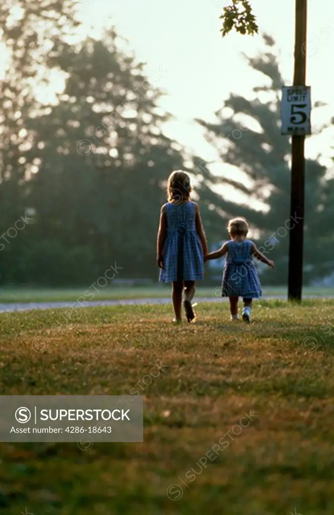 Two sisters walking, holding hands