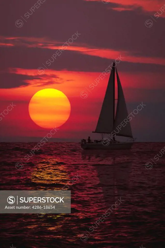 Sailboat with sunset.  Computer montage.