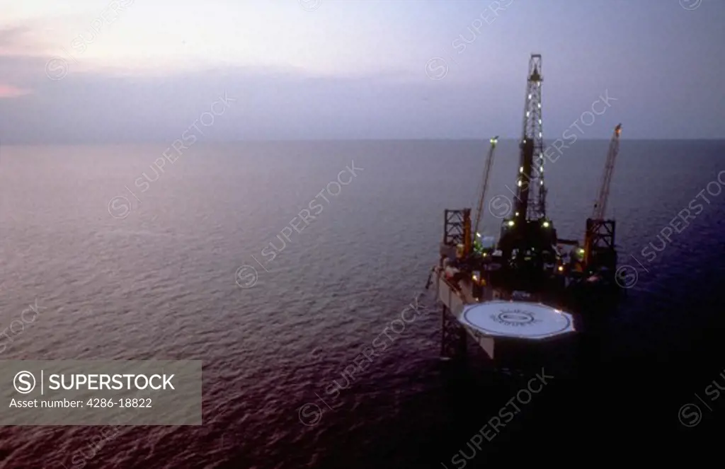 Aerial view of offshore jack-up oil drilling rig at dawn.