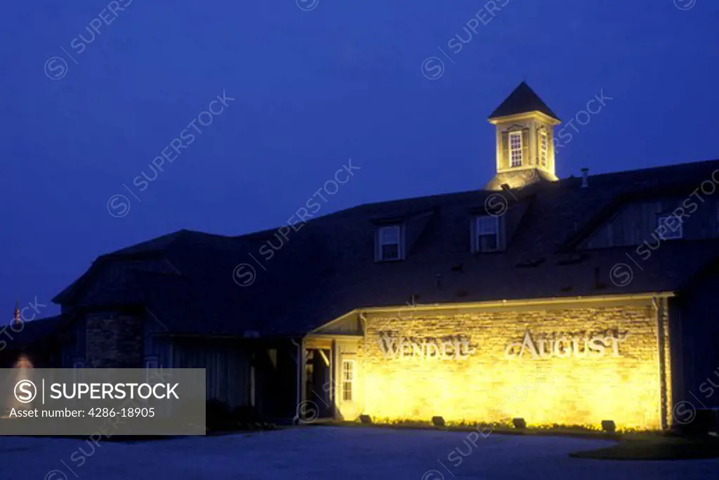 Ohio, Holmes County, Amish, Lights illuminate the front of The Wendell August Forge in the evening.