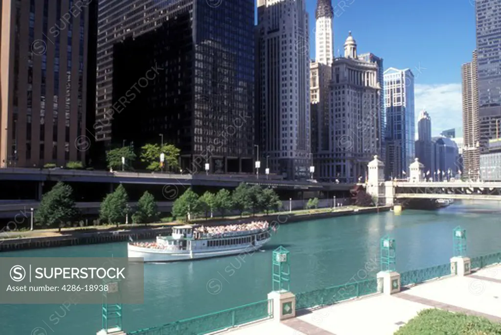 Chicago, Illinois, Skyline of downtown Chicago. Sightseeing tour boat floats along Chicago River.