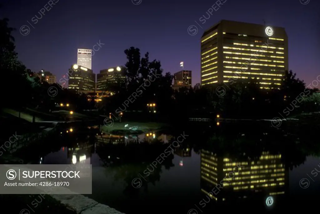Nebraska, The illuminated skyline of downtown Omaha in the evening reflects in the water from the Gene Leahy Mall.