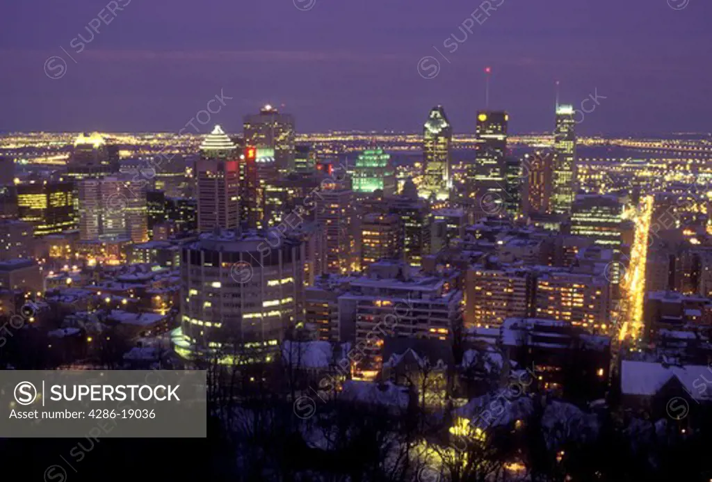 Canada, Quebec, Montreal, Aerial view of the illuminated downtown skyline of Montreal from Mont Royal at night (evening) .