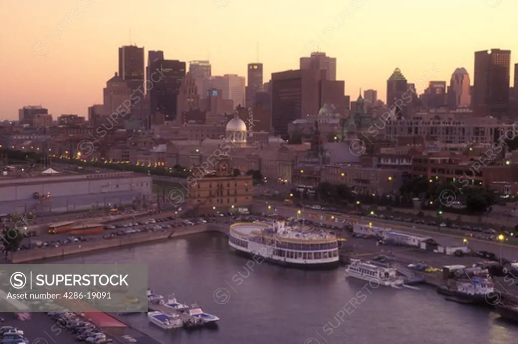 Canada, Quebec, Montreal, Aerial view of Vieux Port and the skyline of downtown Montreal on the waters of St. Lawrence River (Fleuve Saint-Laurent) in the evening.