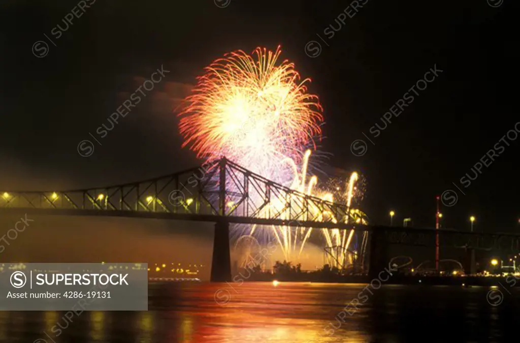 Canada, Quebec, Montreal, Firework display from the International Benson & Hedges Firework Competition reflects on the St. Lawrence River (Fleuve Saint-Laurent) near Pont Jacques Cartier 
