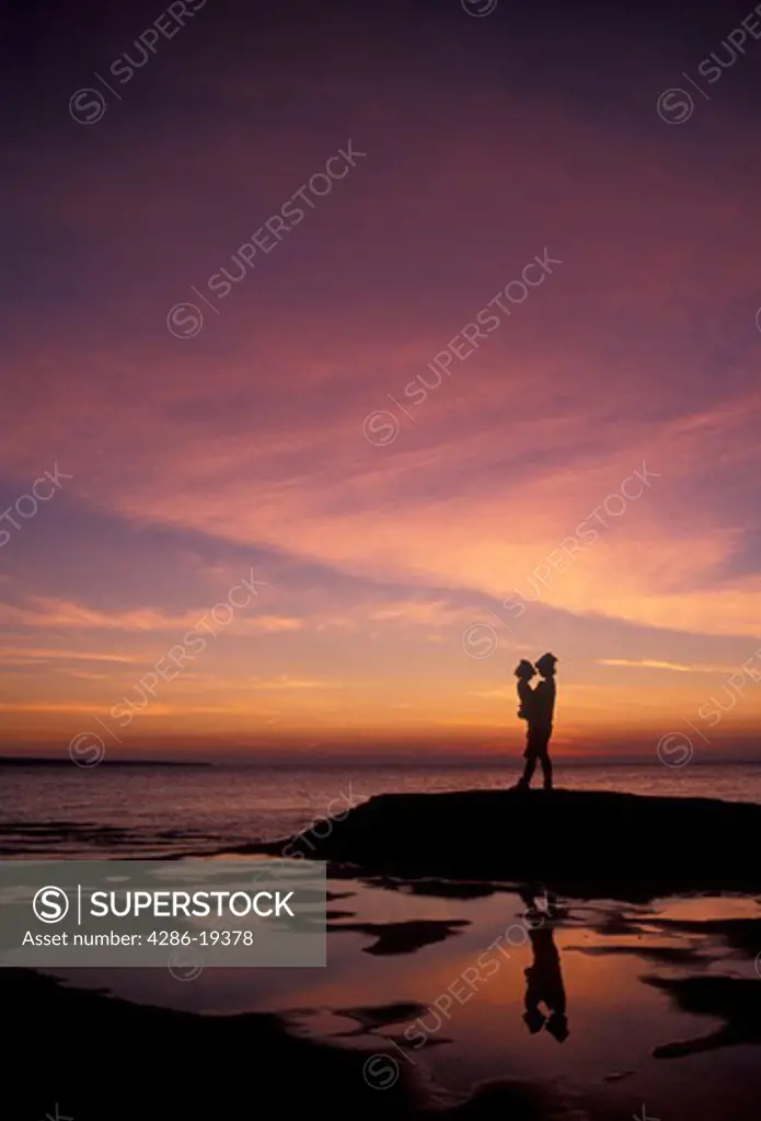sunset, sunrise, silhouette, Lake Superior, Pictured Rocks, Upper Peninsula, U.P., Michigan, Mother and daughter standing on the edge of Lake Superior at sunset at Pictured Rocks National Lakeshore in Munising in the state of Michigan.