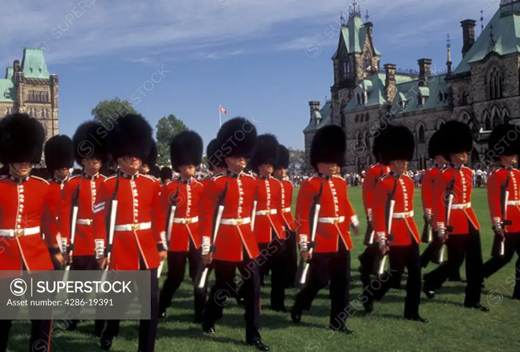 Ottawa, guards, Parliament, Ontario, Canada, Changing of the Guards takes place on the lawn of the Parliament Buildings on Parliament Hill in Ottawa the capital city of Canada in the Province of Ontario. Guards are wearing red jackets, black fuzzy hats, and black pants.