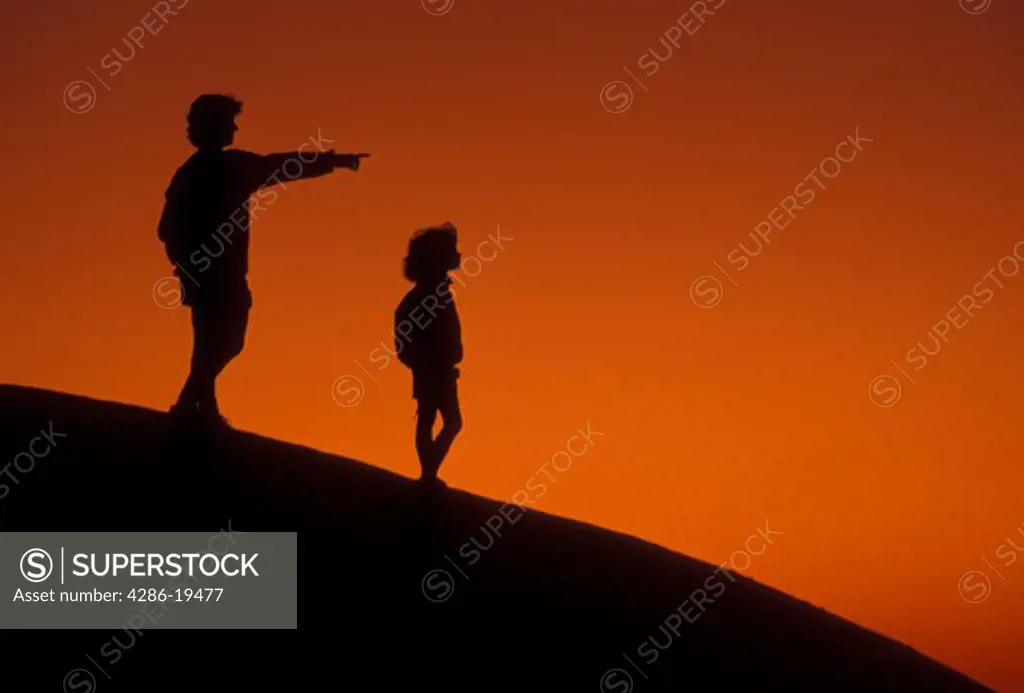 Silhouette, overlook, people, Stone Mountain, Georgia's Stone Mountain Park, Atlanta, Georgia, Silhouette of mother and young daughter watching/looking sunset on the summit of Stone Mountain in Georgia's Stone Mt. Park near Atlanta in the state of Georgia. Mother pointing finger.