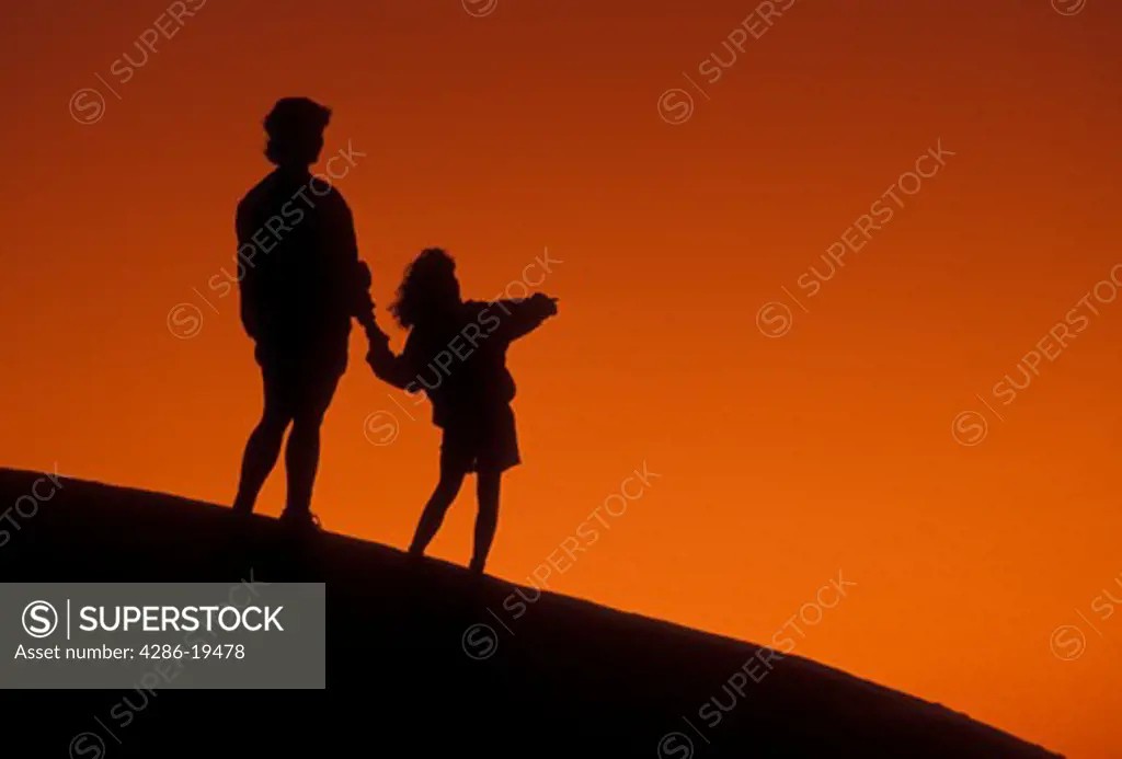 Silhouette, people, overlook, Stone Mountain, Georgia's Stone Mountain Park, Atlanta, Georgia, Silhouette of mother and young daughter holding hands and looking/watching at sunset on the summit of Stone Mountain in Georgia's Stone Mt. Park near Atlanta in the state of Georgia. 