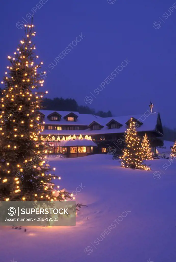 lodge, resort, inn, Trapp Family Lodge, Christmas, X-mas, Xmas, winter, trees, Vermont, The snow covered Trapp Family Lodge is decorated with lights in the evening for the Christmas holiday season in Stowe in Lamoille County in the state of Vermont. Evergreen trees with tiny white lights stand on the front lawn of the lodge.