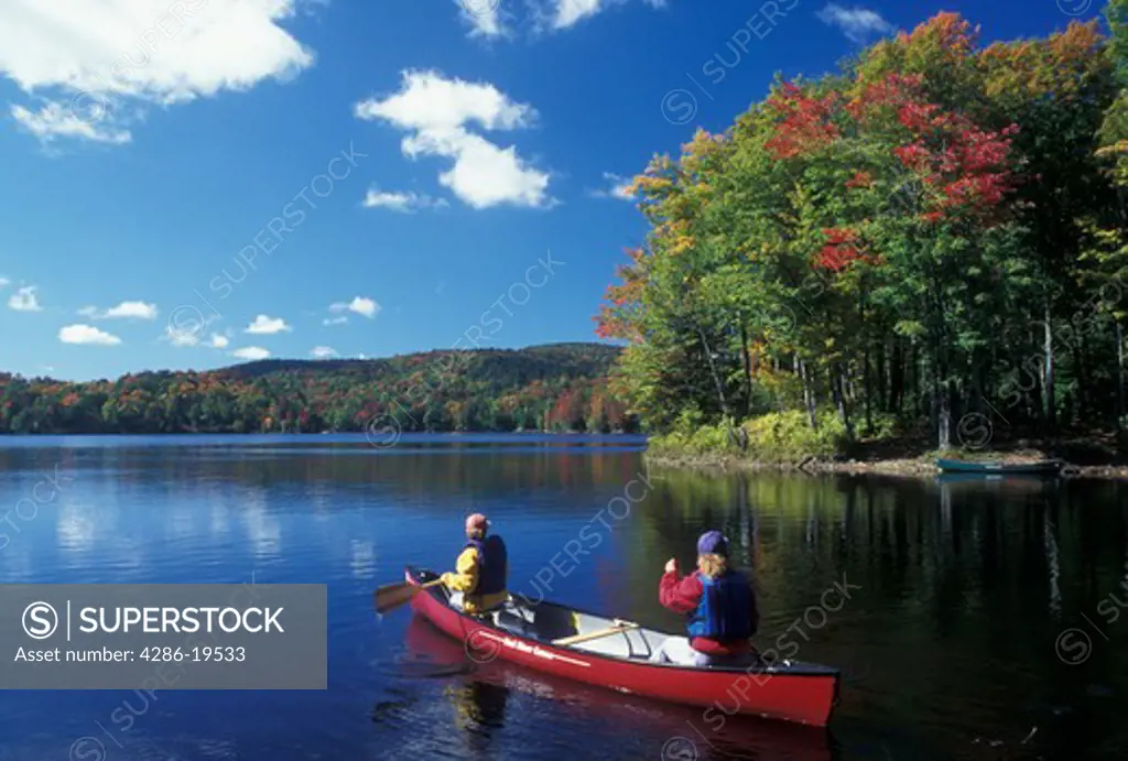 canoe, canoeing, Vermont, VT, Mother and daughter paddle a red canoe on Green River Reservoir in Hyde Park in the fall. 