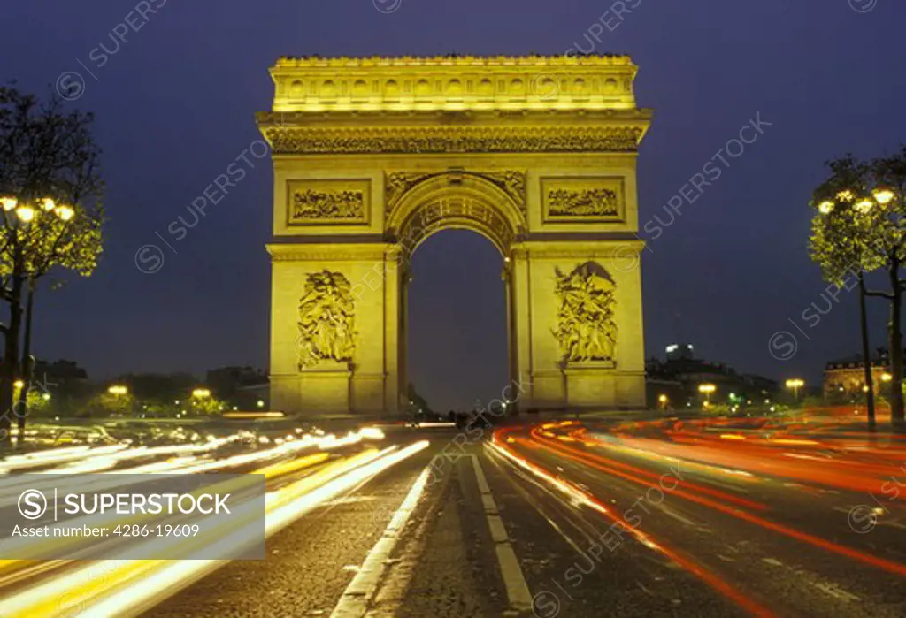 Arc de Triomphe, Paris, France, Europe, Arc de Triomphe at Place Charles de Gaulle illuminated at night in Paris. Headlights of traffic passing along the Avenue des Champs Elysees.