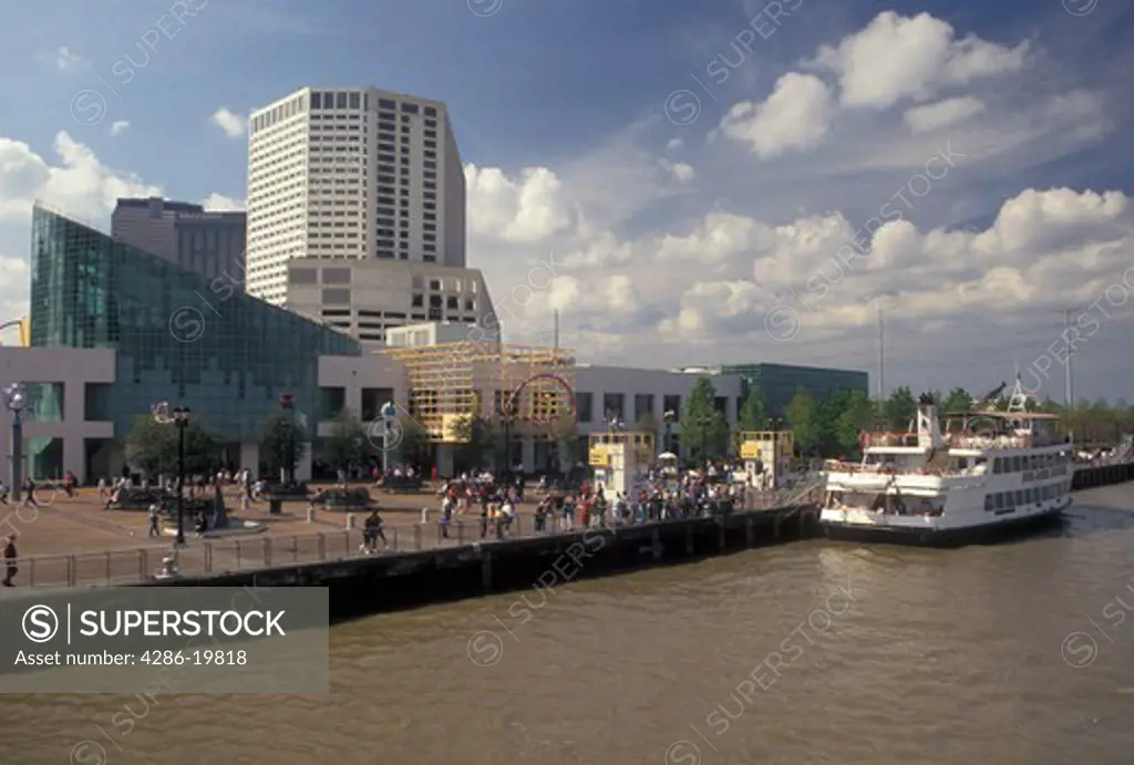 skyline, New Orleans, Louisiana, LA, View of the Aquarium of the Americas and downtown skyline of New Orleans along the Mississippi River. Passenger ferry along the riverfront.
